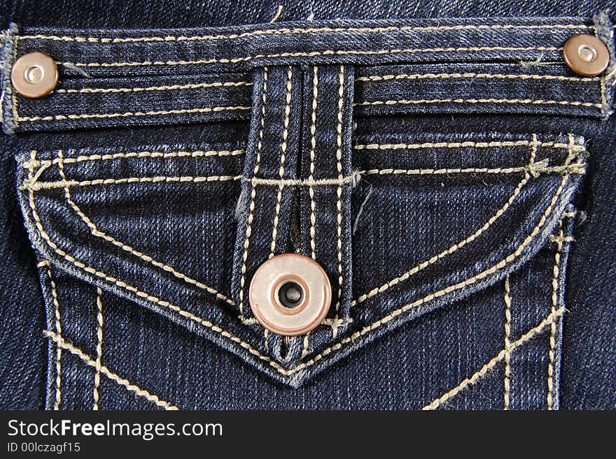 Closeup of a blue jeans pocket with three metal buttons