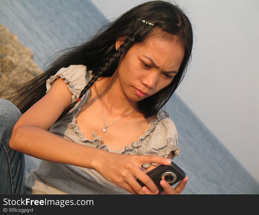 Girl on Mactan island, sending SMS home to friends. Girl on Mactan island, sending SMS home to friends