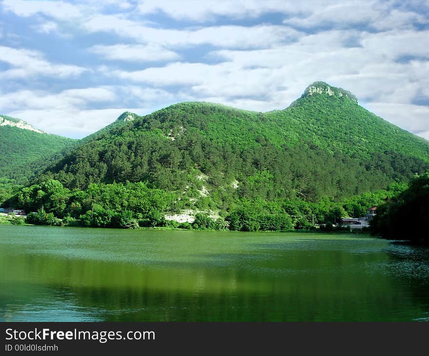 Beautiful landscape (big mountain, green lake and sky with clouds)