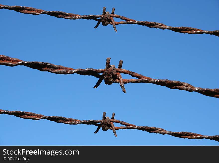 Rusty Barbed Wire against a blue sky