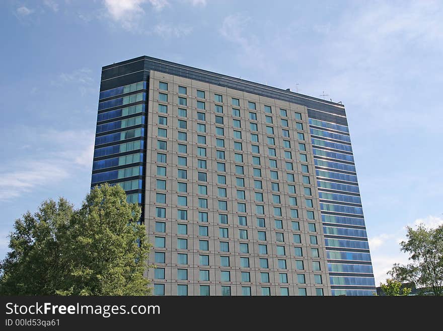 A blue glass and grey stone hotel or condo. A blue glass and grey stone hotel or condo