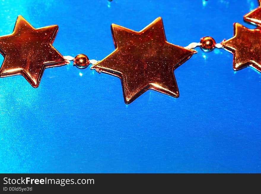 Orange Christmas stars on blue background (shallow DOF)