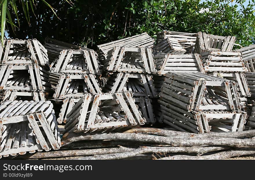 A pile of traps lie nearby the caribbean ocean. Commercial fishermen use these to trap crabs in the clear blue waters off the coast of Belize. A pile of traps lie nearby the caribbean ocean. Commercial fishermen use these to trap crabs in the clear blue waters off the coast of Belize