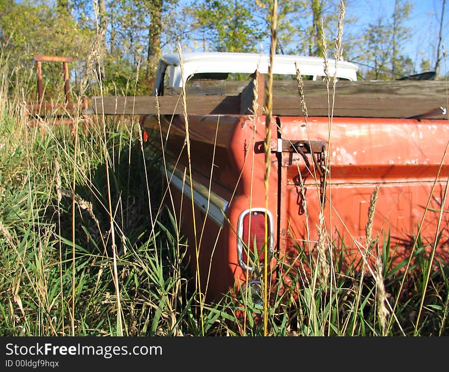 The tailgate of an old truck rusting away in a junkyard. The tailgate of an old truck rusting away in a junkyard.