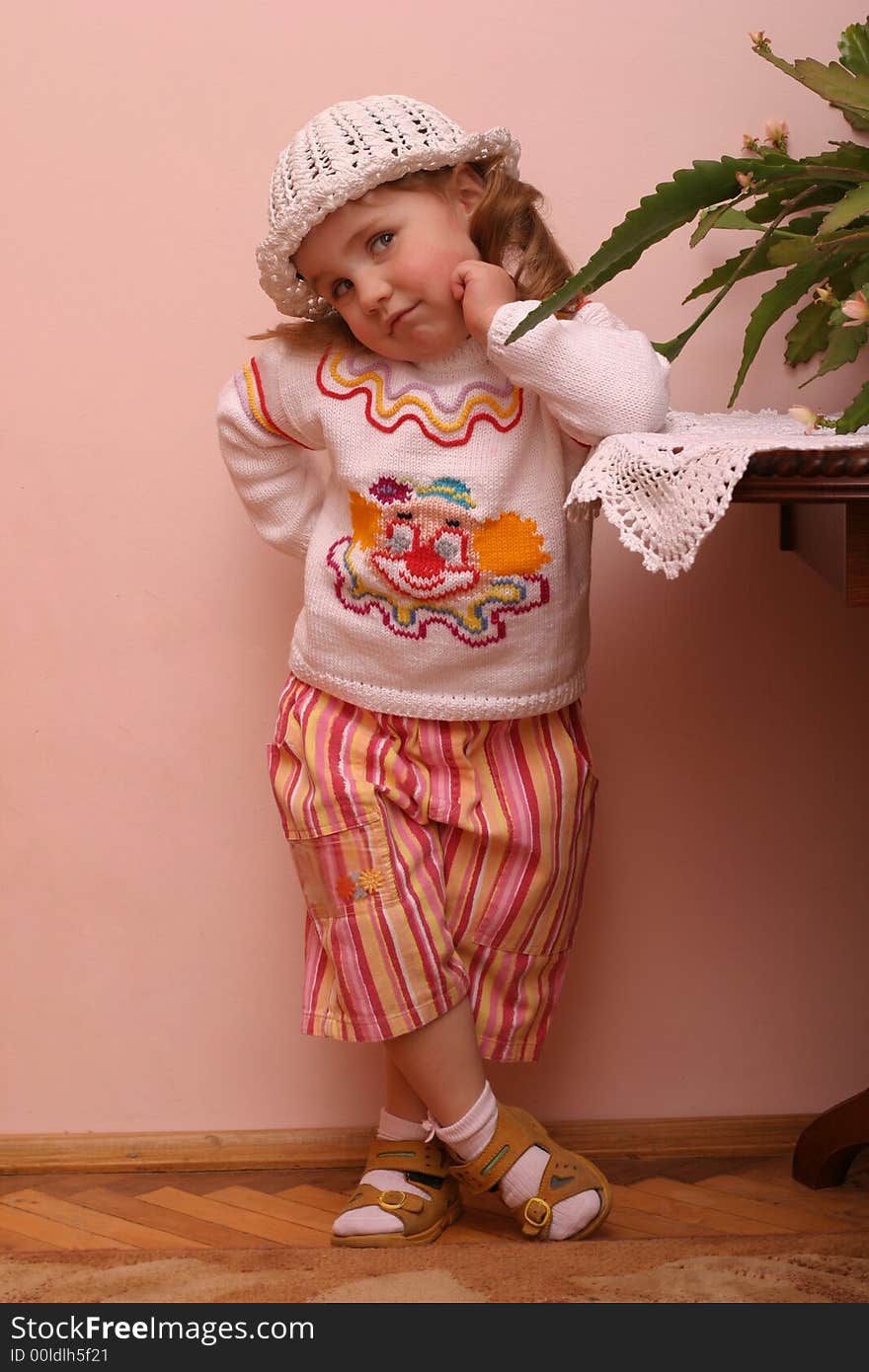 Little girl in funy clothes pose over interior wall