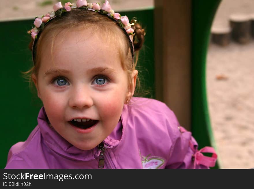 Smiley little girl over defocused playground background