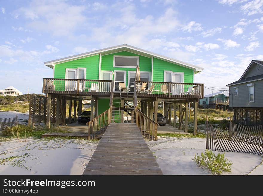 Bright green house on beach with deck and boardwalk. Bright green house on beach with deck and boardwalk