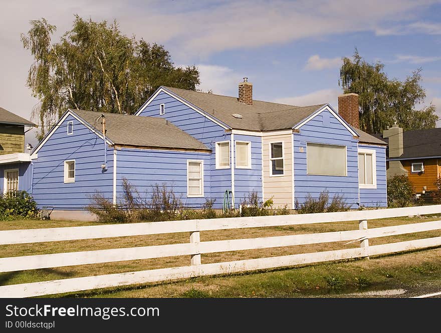 A small house in the country with white fence. A small house in the country with white fence