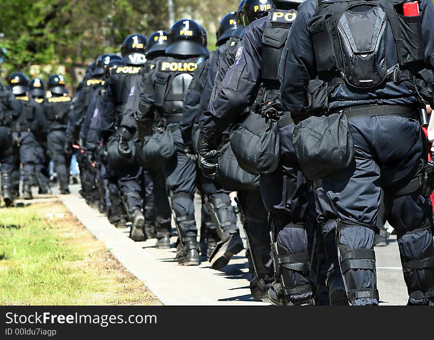 Policemen waling towards the action in a row. Policemen waling towards the action in a row