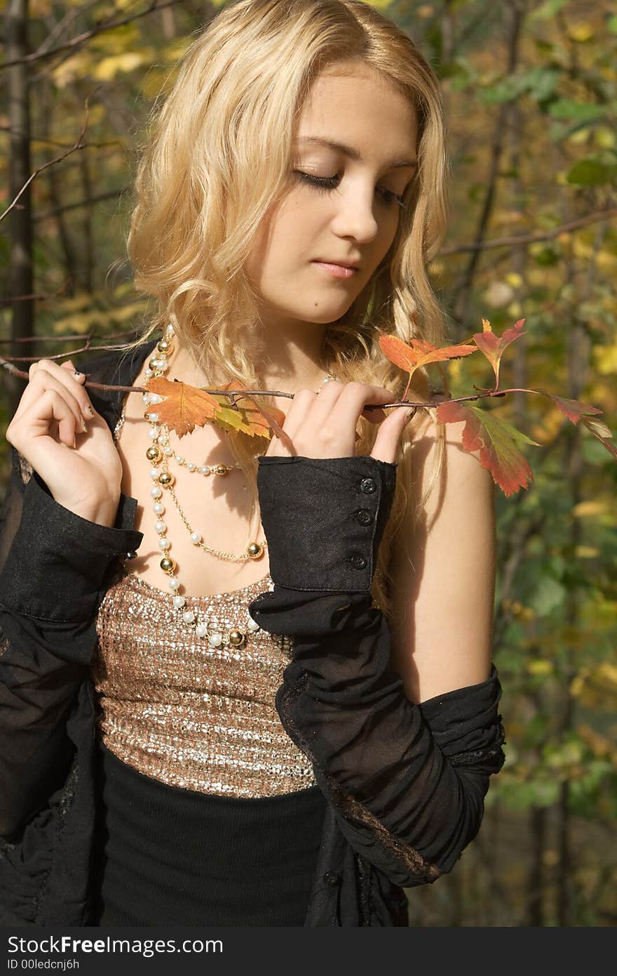 Portrait of beautiful blond girl in autumn park