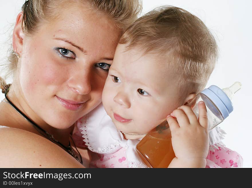 Happy mother holds on hands of the baby with a bottle. Happy mother holds on hands of the baby with a bottle