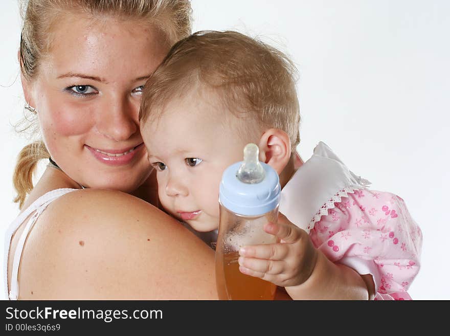 Happy mother holds on hands of the baby with a bottle. Happy mother holds on hands of the baby with a bottle