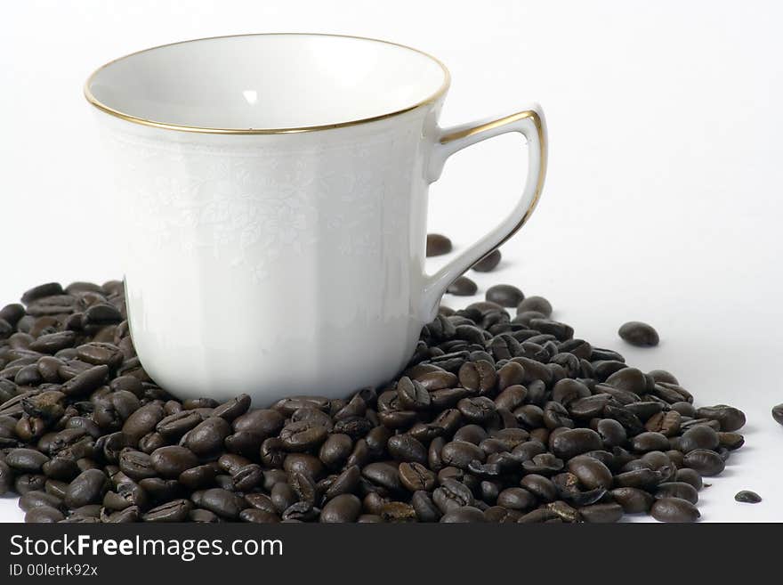 A coffee cup sitting in a pile of coffee beans. A coffee cup sitting in a pile of coffee beans