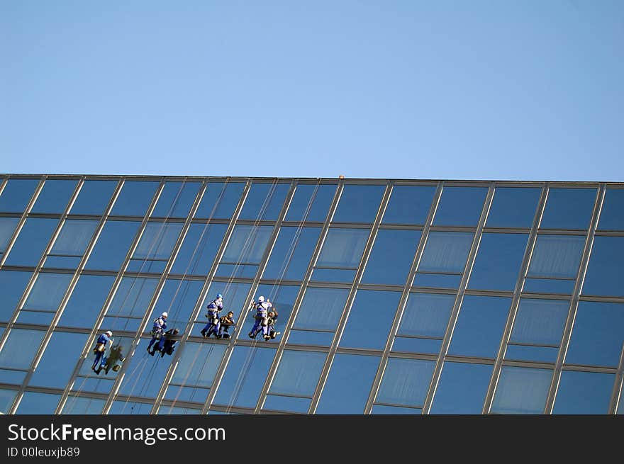 Four cleaners washing the glass building. Four cleaners washing the glass building