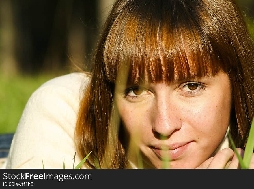 Young girl lying on the grass, close portrait