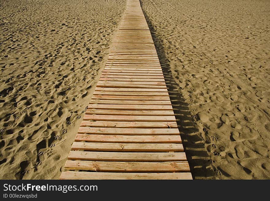 A wood way on the sand in a beach of Fuerteventura in the Canary Islands. A wood way on the sand in a beach of Fuerteventura in the Canary Islands