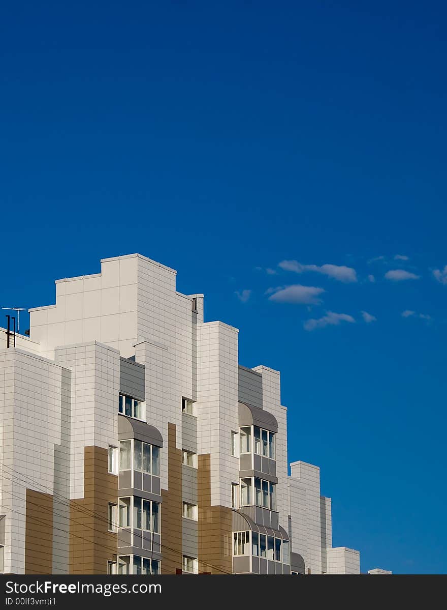 Photo of toy like building with bkue sky on the background. Poster-like picture.