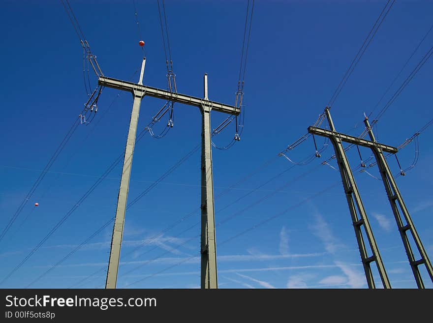 Electrical power lines, isolators and mast in blue cloudy sky, horizontal. Electrical power lines, isolators and mast in blue cloudy sky, horizontal.