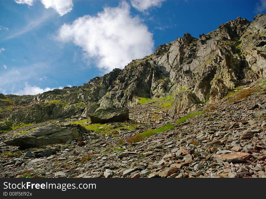 A panoramic view on Swiss Alps rocky mountains with many wild rocks in front. Horizontal. Zermat, Switzerland, Europe. A panoramic view on Swiss Alps rocky mountains with many wild rocks in front. Horizontal. Zermat, Switzerland, Europe.