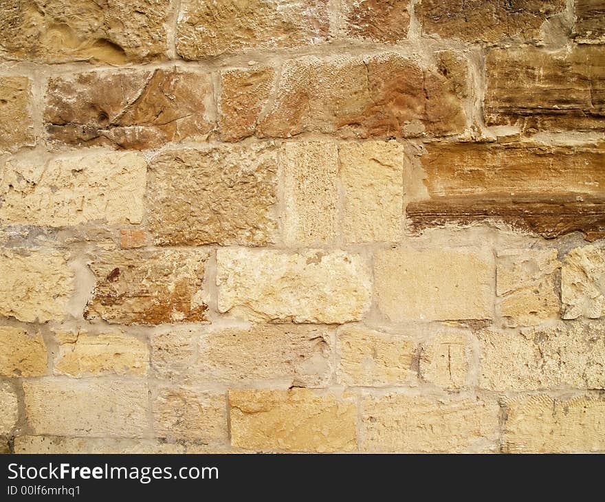 Horizontal view of a layered, sandstone exterior wall building facade. A close up of a brick wall which can be used as background. Horizontal view of a layered, sandstone exterior wall building facade. A close up of a brick wall which can be used as background