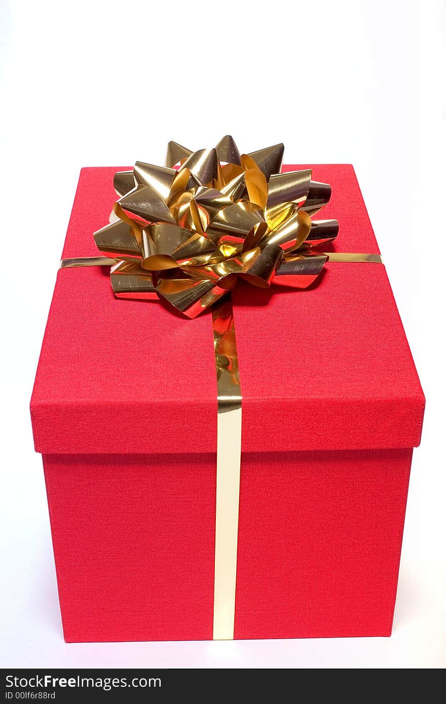 Red gift box with a gold bow on white. Red gift box with a gold bow on white