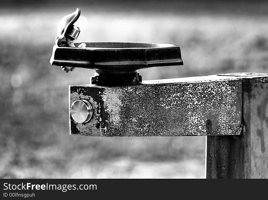 A weathered water fountain in black and white at Losco Park in Jacksonville Florida