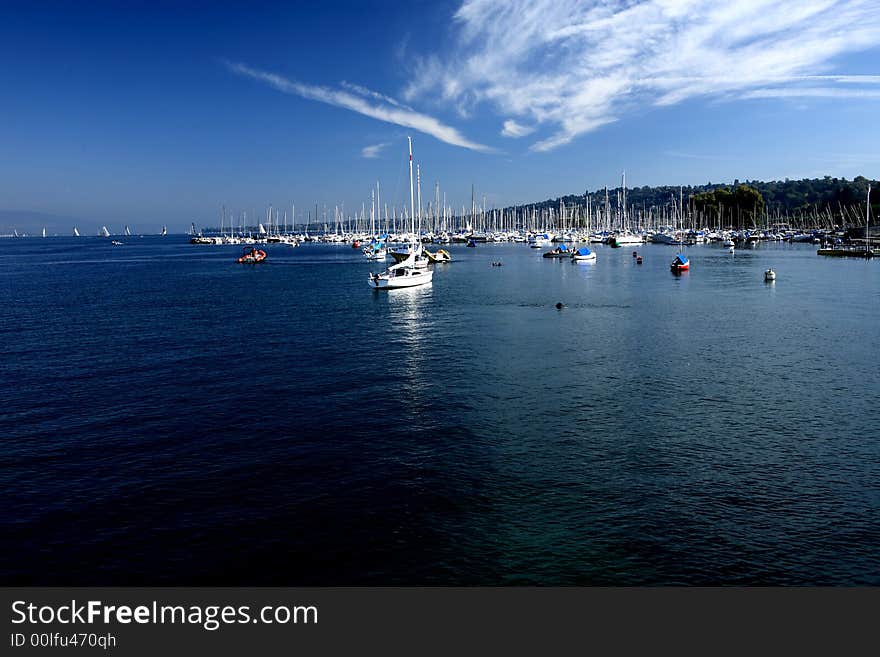 Ships in Leman Lake construct typical Swiss scenery. Floating clouds in the sky express a warm day.