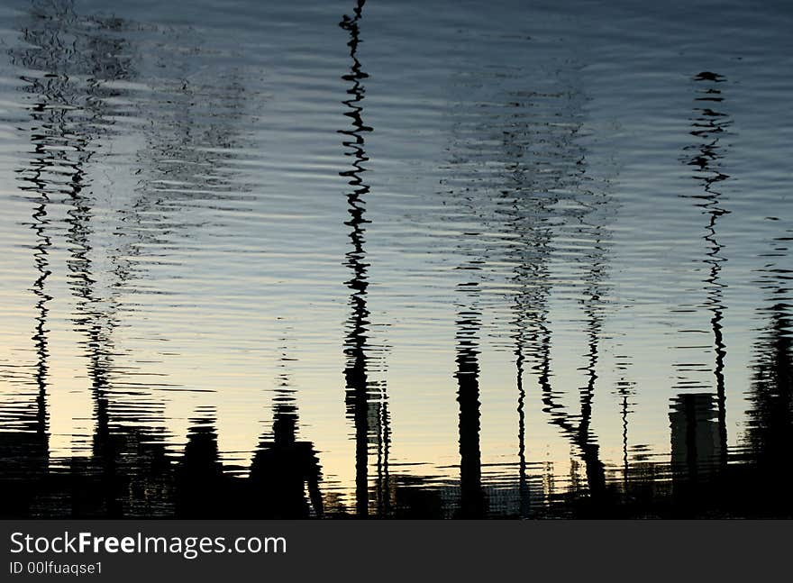 Silhouettes reflected on water on a park