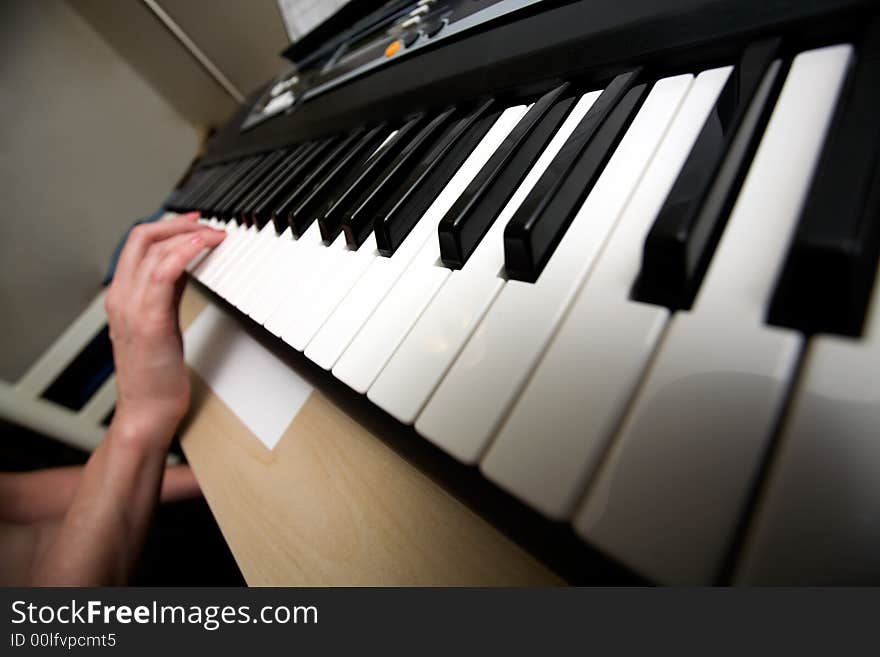 Diagonal view of hands on the keys of a keyboard. Diagonal view of hands on the keys of a keyboard