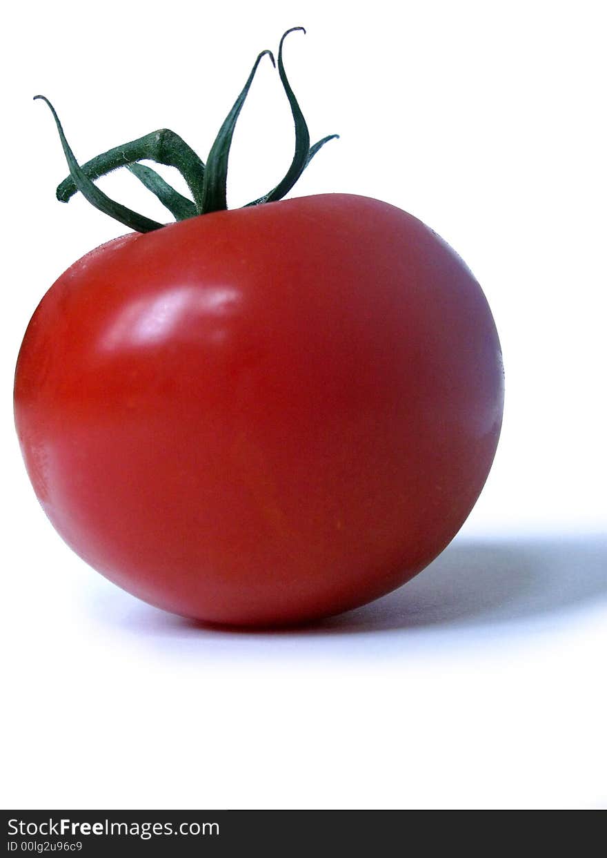 Single tomato on a white background, shot from the side. Single tomato on a white background, shot from the side