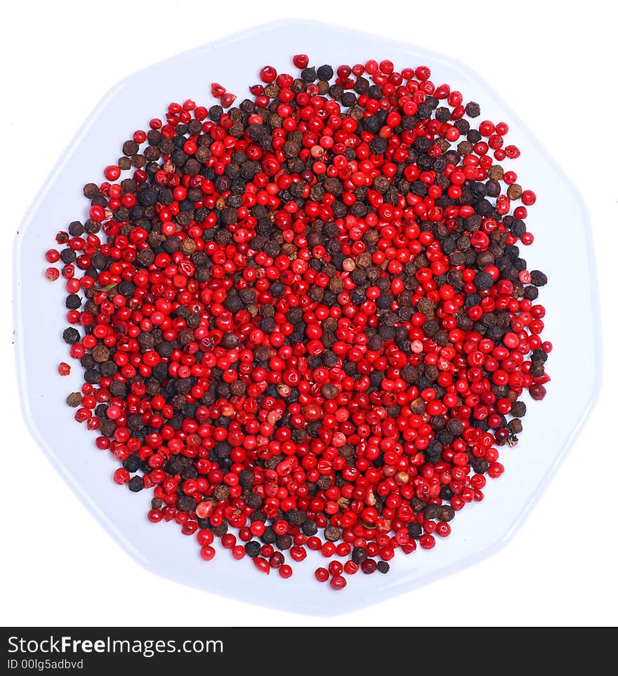 Dried black and red peppercorns on the white plate