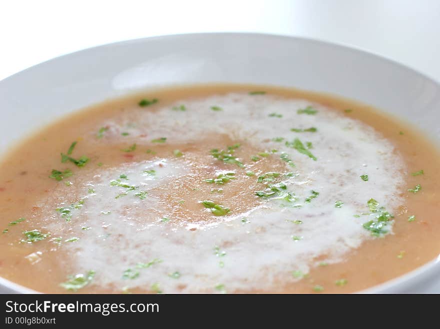 Cream of pumpkin soup with a swirl of whipped cream and sprinkle of Chinese parsley