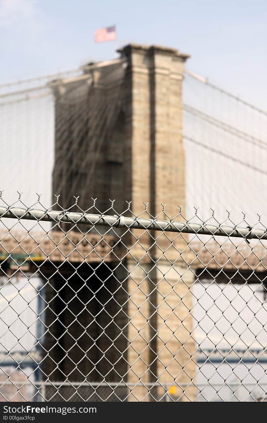 Barbed wire fence with brooklyn bridge in background