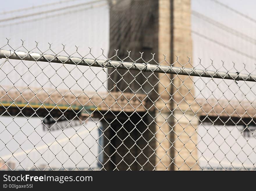 Barbed wire fence with brooklyn bridge in background