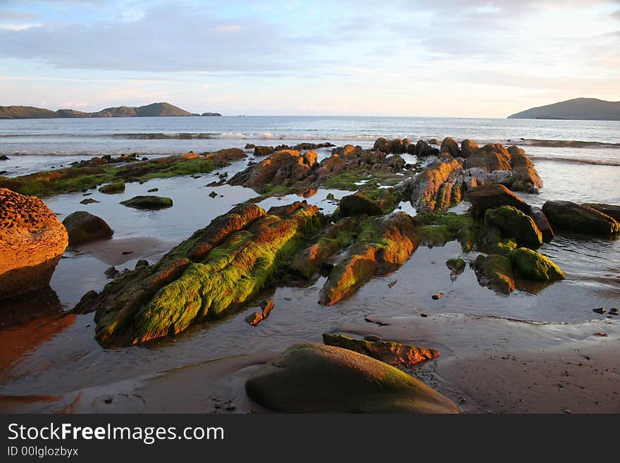 Moss covered rocks glisten at sunset in Ballinskelligs Bay, County Kerry, Ireland. Moss covered rocks glisten at sunset in Ballinskelligs Bay, County Kerry, Ireland