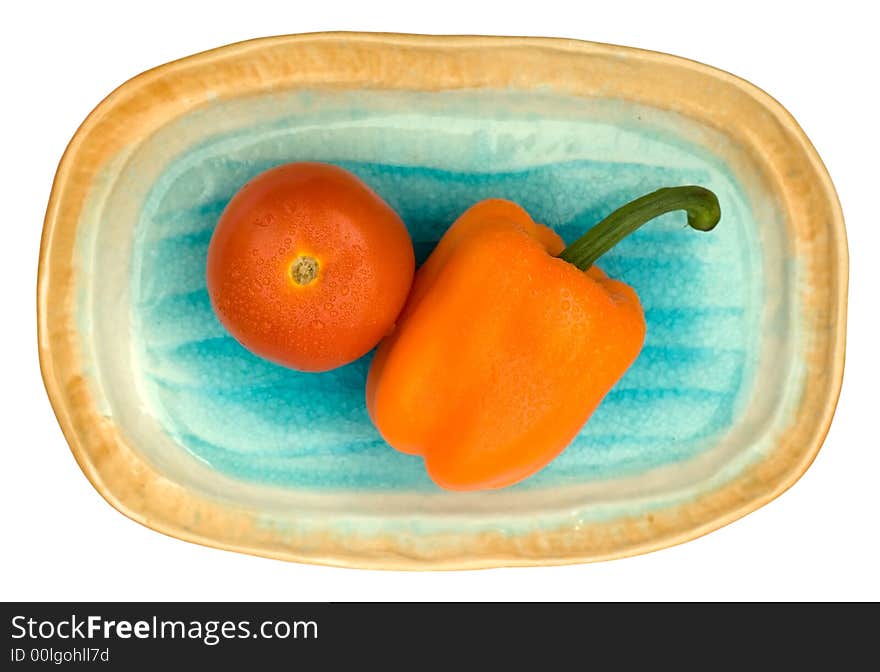 Tomato and capsicum on a oval shelling plate. Tomato and capsicum on a oval shelling plate