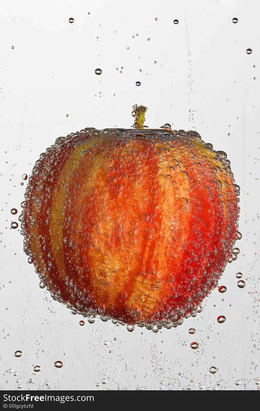 Fresh apple in a clear bubbly liquid on a white background. Fresh apple in a clear bubbly liquid on a white background.