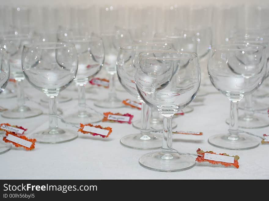 Rows of water glasses with name tags, on a linen tablecloth. Rows of water glasses with name tags, on a linen tablecloth