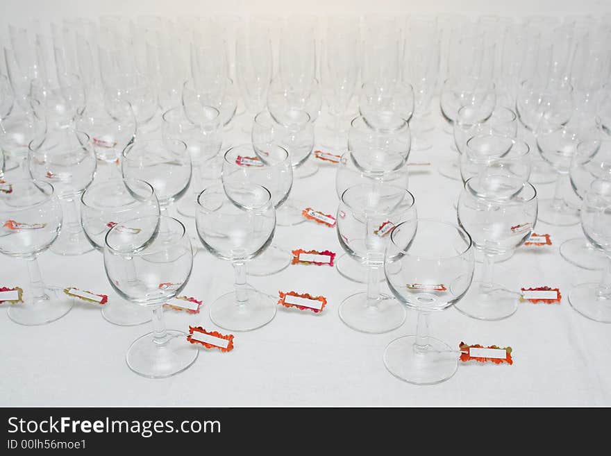 Rows of water glasses with name tags, on a linen tablecloth. Rows of water glasses with name tags, on a linen tablecloth