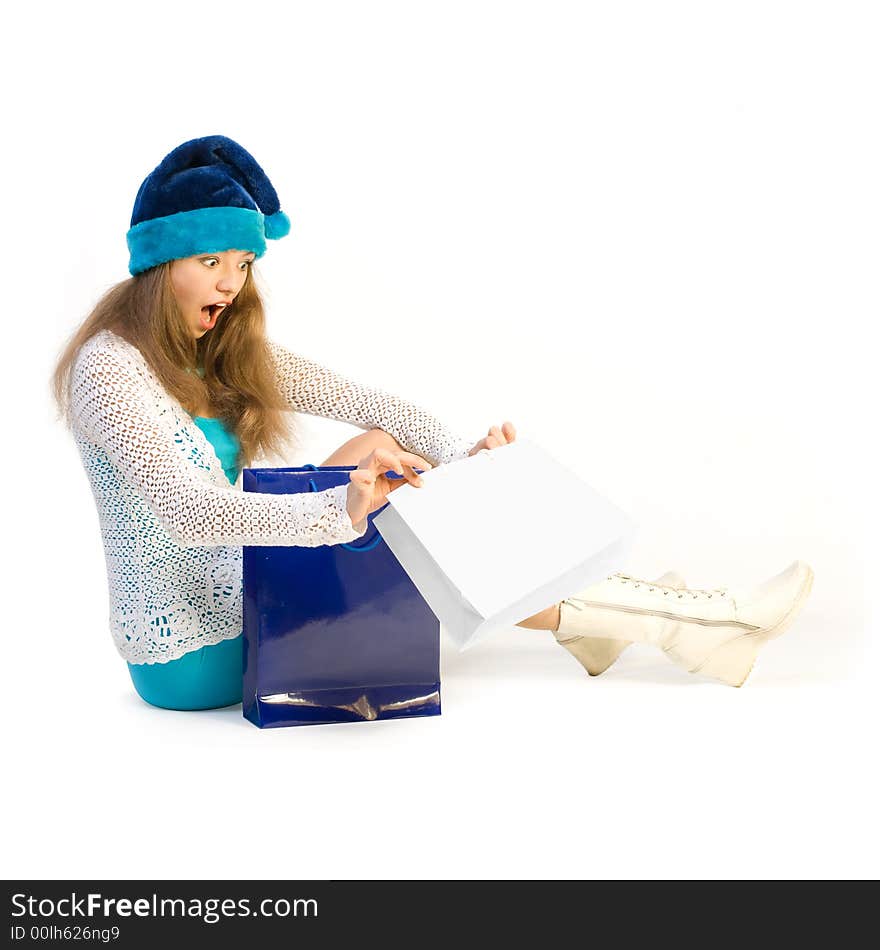 girl with delight looks in shoppingbag over white. girl with delight looks in shoppingbag over white