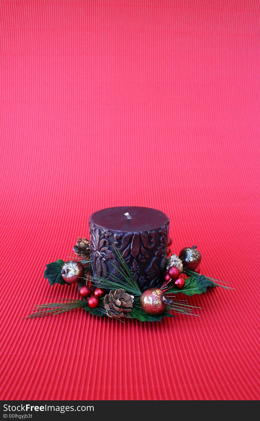 Dark pattern candle with a wreath on a red background. Dark pattern candle with a wreath on a red background