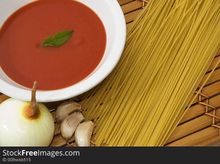 Spaghetti, tomato sauce, garlic and basil leaves on wood background. Spaghetti, tomato sauce, garlic and basil leaves on wood background