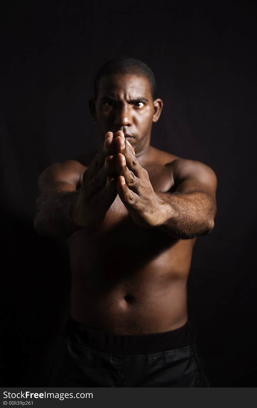 Portrait of young shirtless afroamerican male practising martial arts - isolated over black background. Portrait of young shirtless afroamerican male practising martial arts - isolated over black background