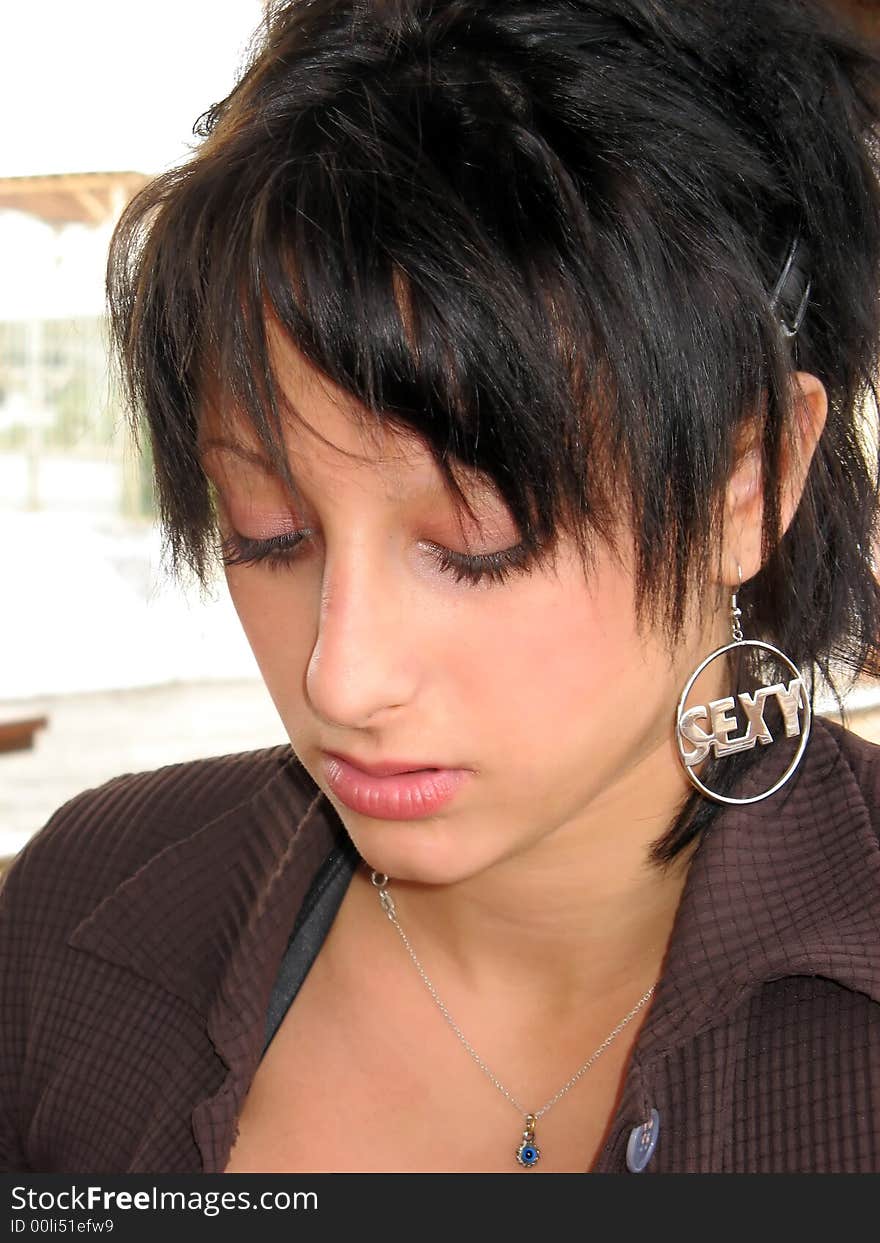 Young woman, face, looking down, thinking. Short dark hair. Young woman, face, looking down, thinking. Short dark hair