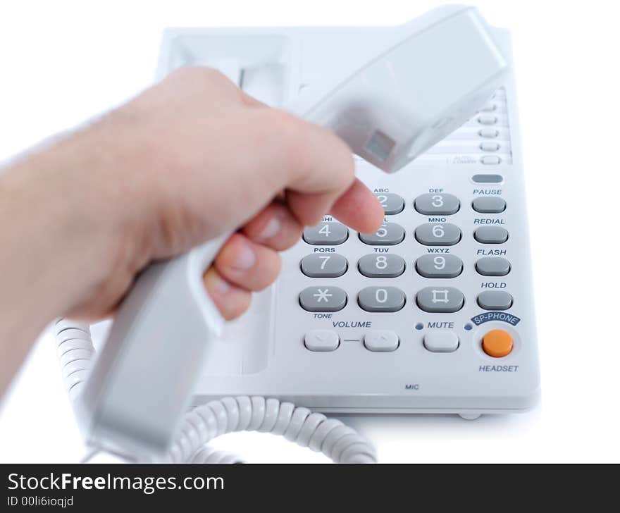 Male hand typing phone number on white telephone isolated over white background. Male hand typing phone number on white telephone isolated over white background