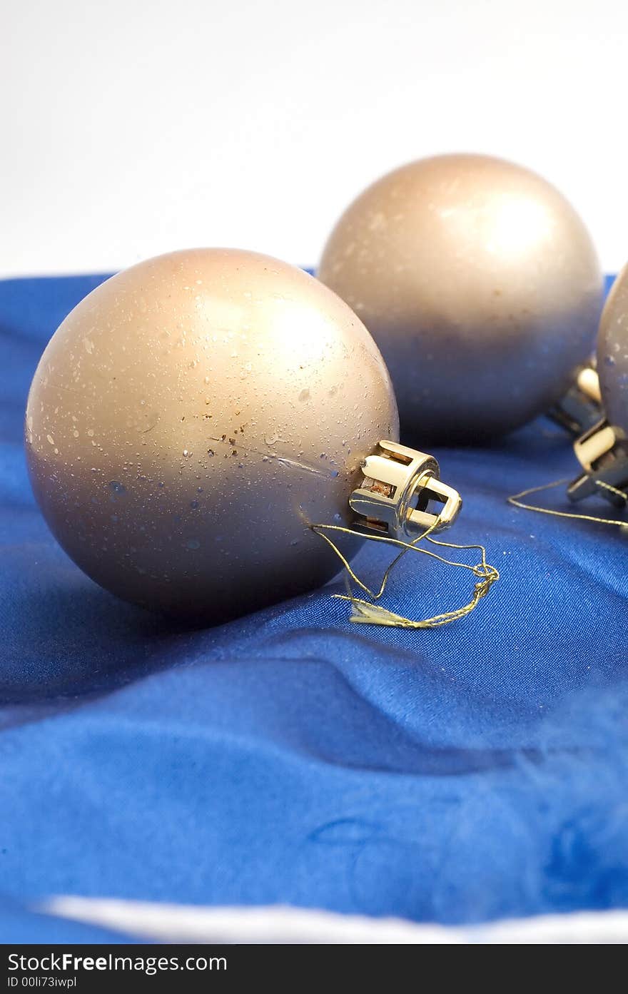 Golden Christmas tree decoration bulb on blue satin.