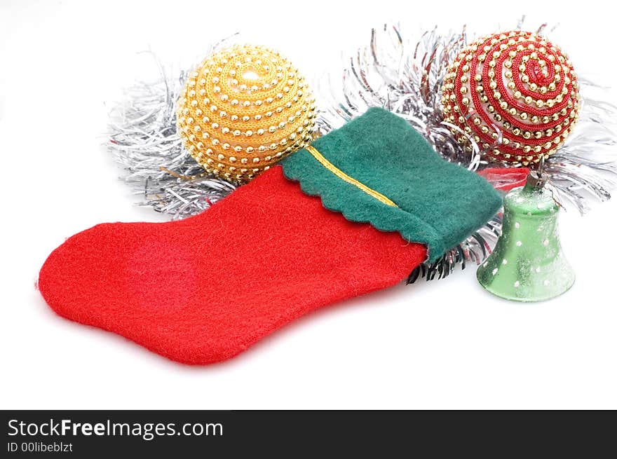 Photograph of Christmas stocking on white background with Christmas tree decorations.