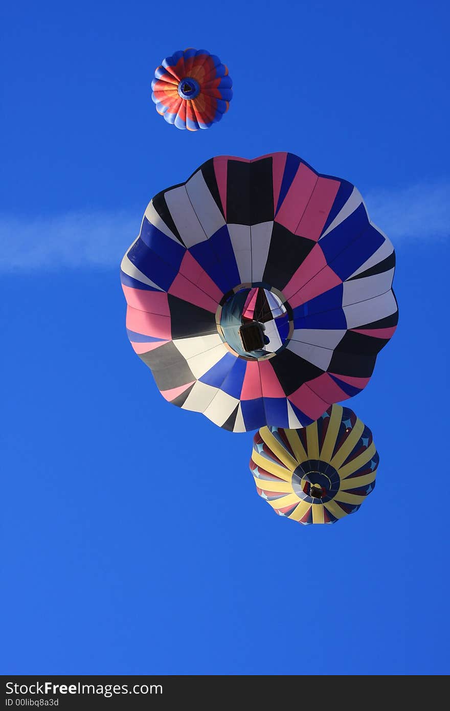 Three hot air balloons directly overhead. Three hot air balloons directly overhead.