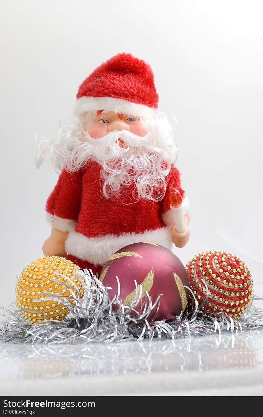 Santa claus toy on white background with Christmas tree decorations.