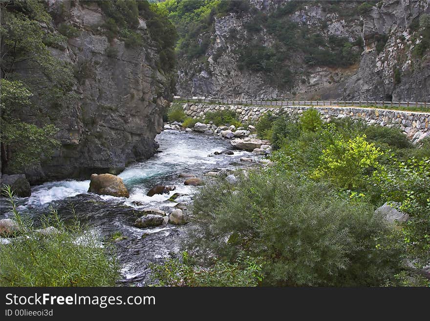 The mountain river in the French Alpes and high-mountainous road. The mountain river in the French Alpes and high-mountainous road